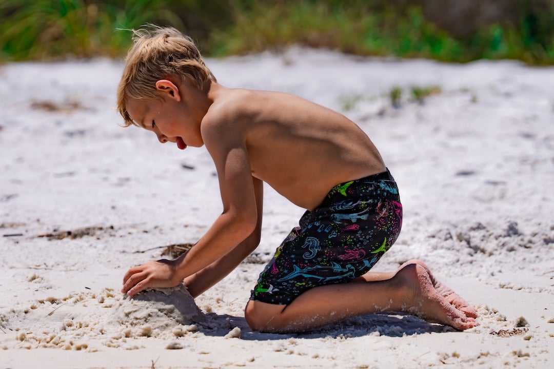 child playing in the sand at makaph island in okaloosa county