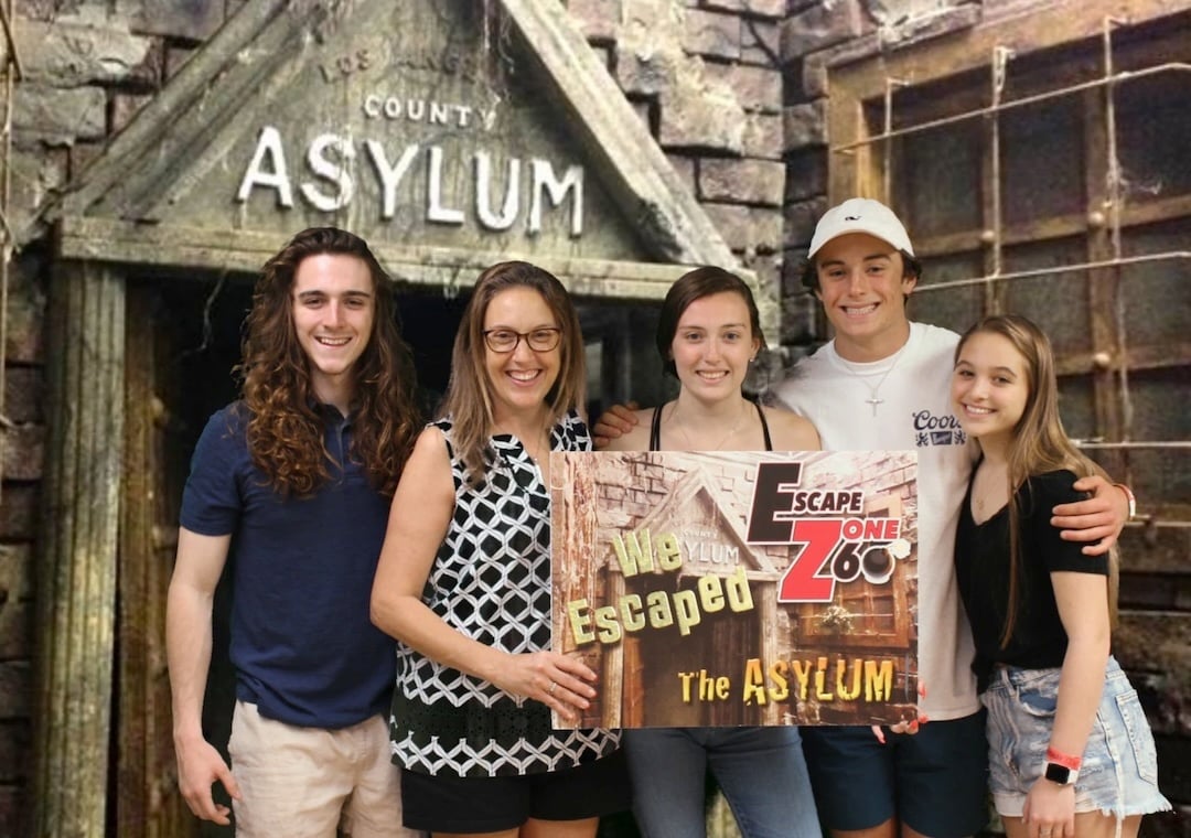 group posing and holding a sign at escape room 60