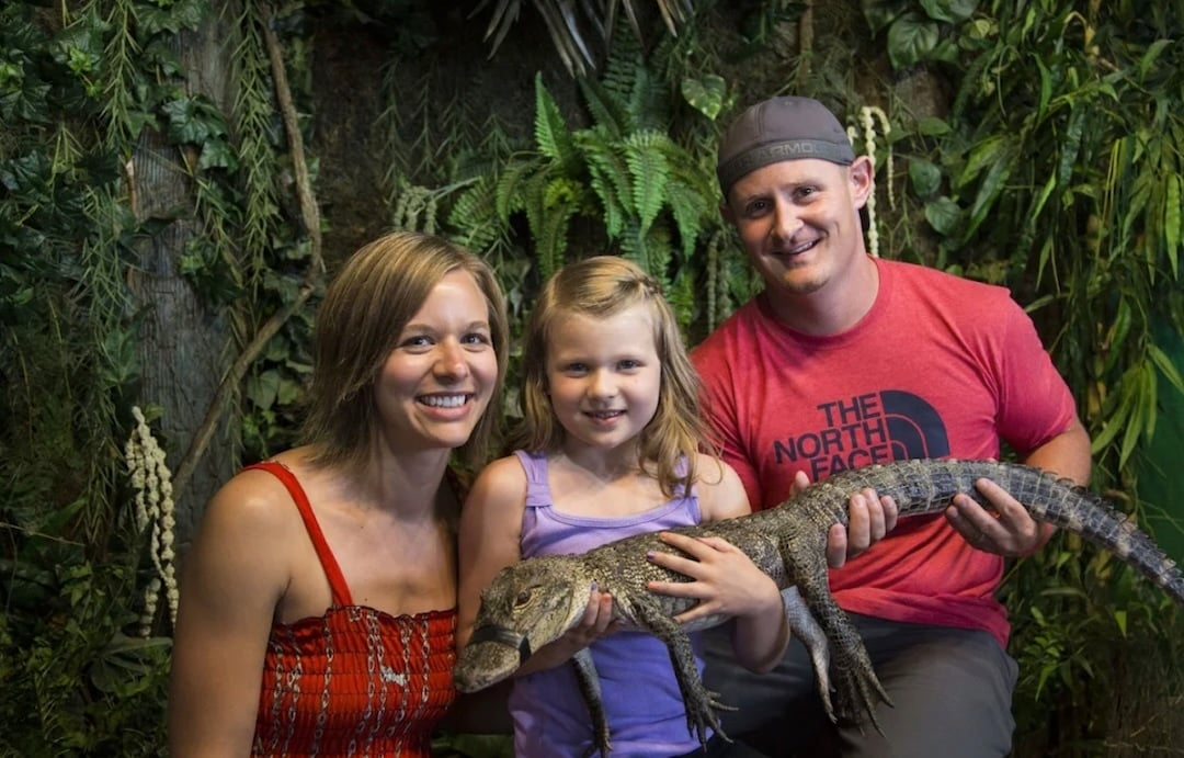 family holding gator at gator beach destin