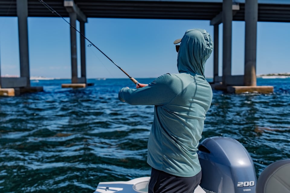 man fishing near the destin harbor bridge in choctawhatchee bay