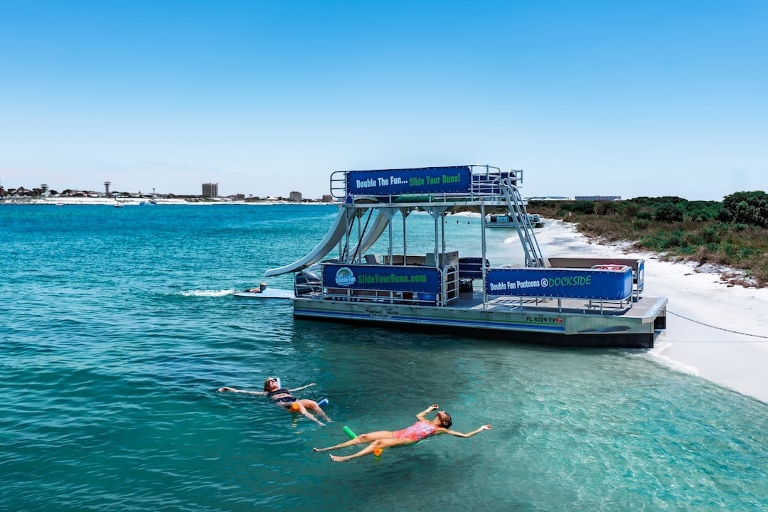 girls floating beside beached pontoon