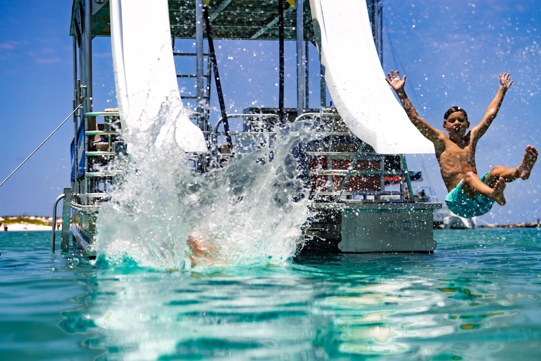 kids sliding into water from pontoon upper deck