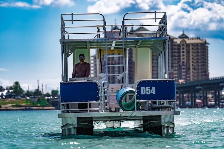 man driving double decker pontoon boat rental near crab island in destin florida