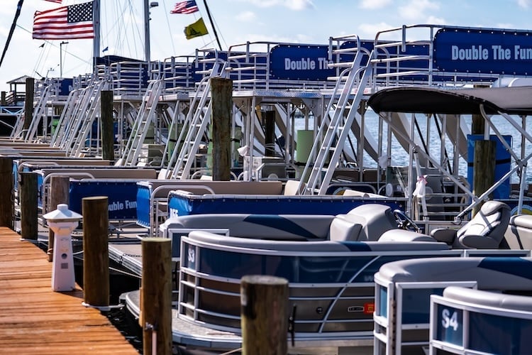 row of docked pontoon boat rentals parked in panama city beach upper grand lagoon
