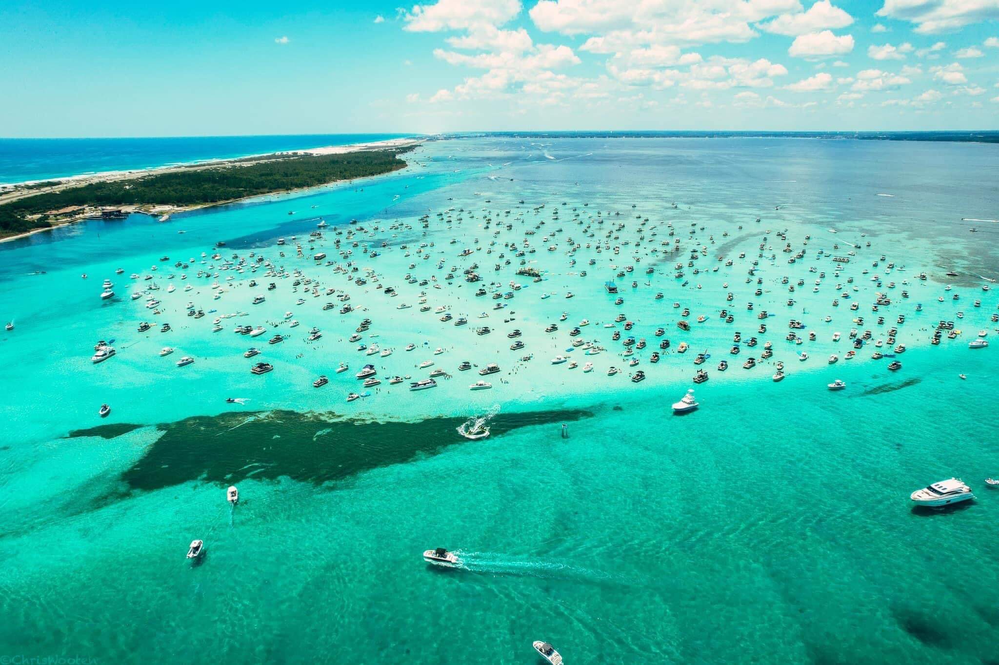 aerial shot of lots of boats parked at crab island in destin florida