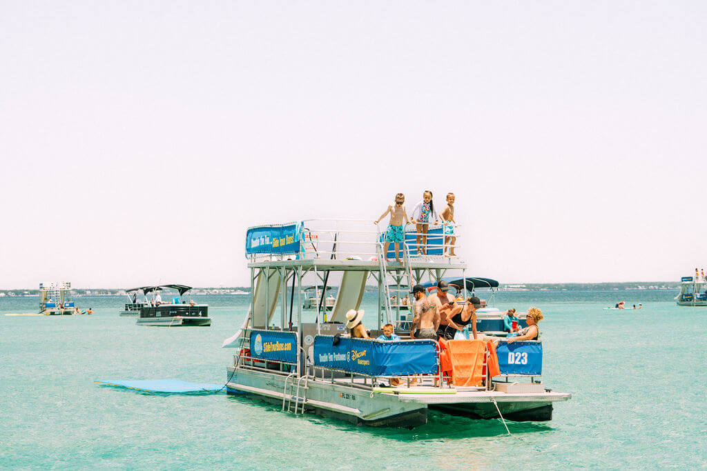 family on a double decker pontoon boat with two waterslides in destin, florida