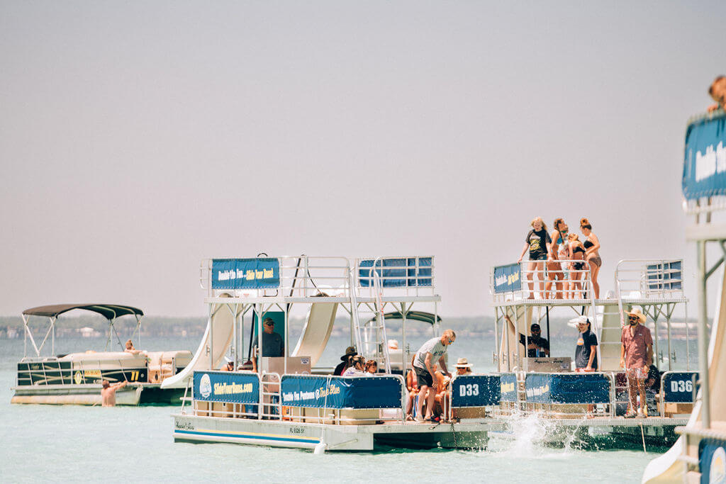 people standing on two double decker pontoon boats