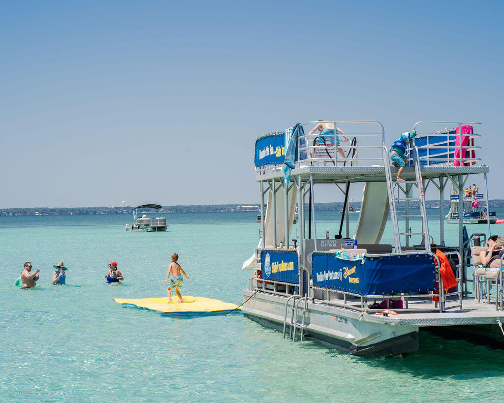 a float attached to a double decker pontoon boat in destin, florida near crab island