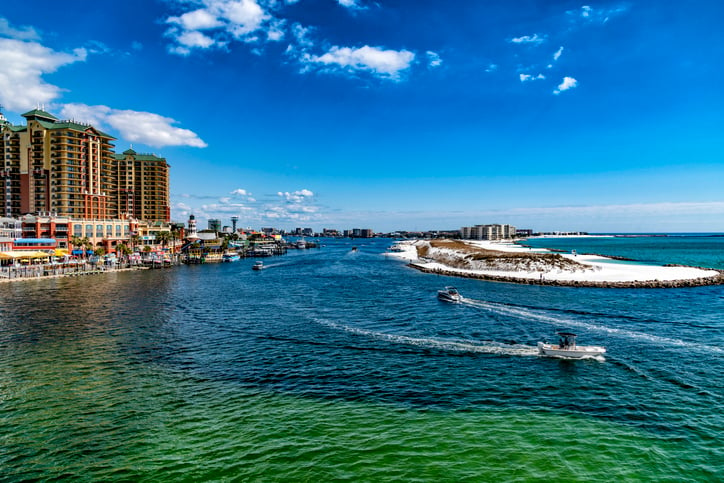 Destin Harbor with boats driving through it