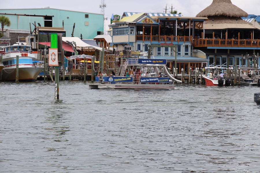 double decker pontoon boat driving through the ocean in the destin florida marina