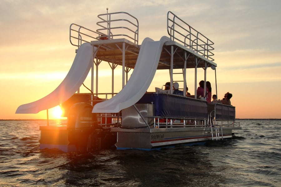 double decker pontoon boat with a sunset in the background in destin, florida