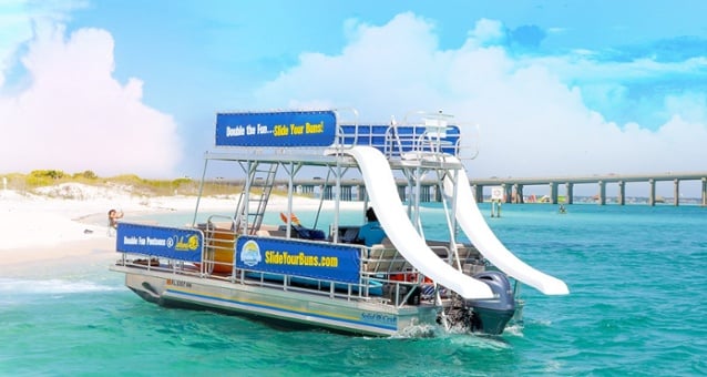 double decker pontoon boat with two slides parked off of west jetty beach in destin, florida 
